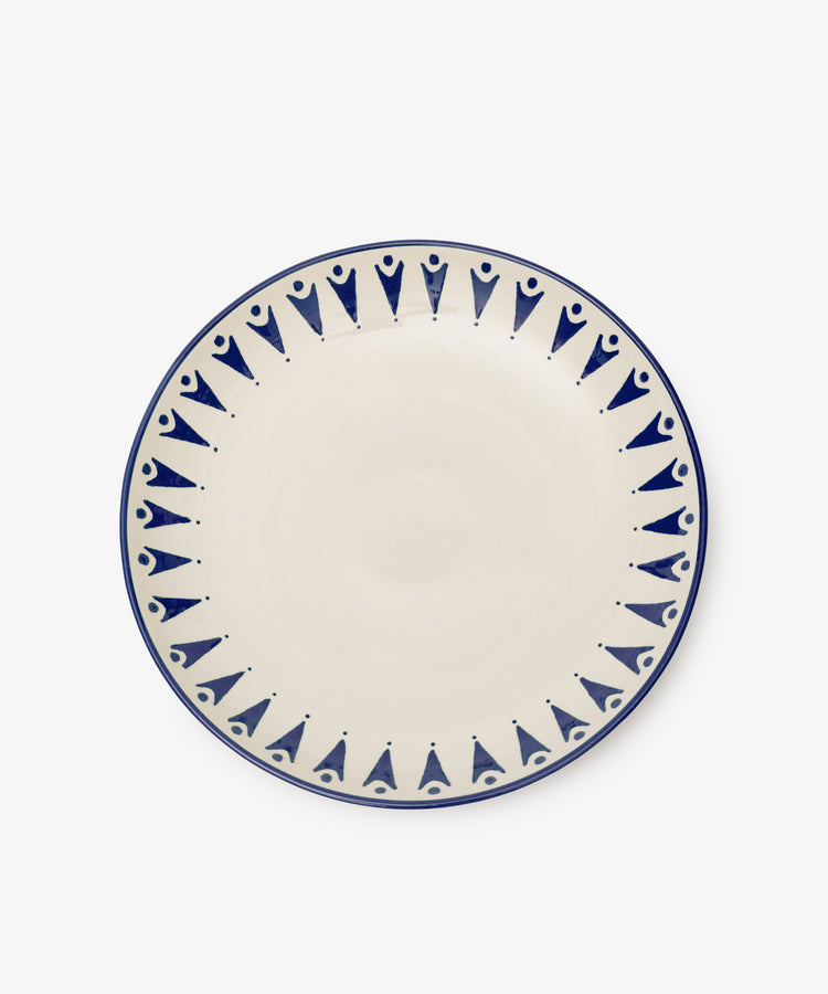 The Vito Serving Platter is a round ceramic piece with a cream center and blue geometric rim, showcasing understated handmade style.