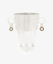 The Inge Ice Bucket is a silver metal ice bucket with two ring handles and three textured legs, highlighting fine Italian craftsmanship, shown against a plain white background.