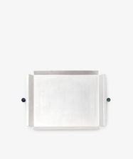 The Freya Serving Tray features a minimal natural stone color with raised edges and two spherical stone handles—one dark blue and one green—on opposite sides.