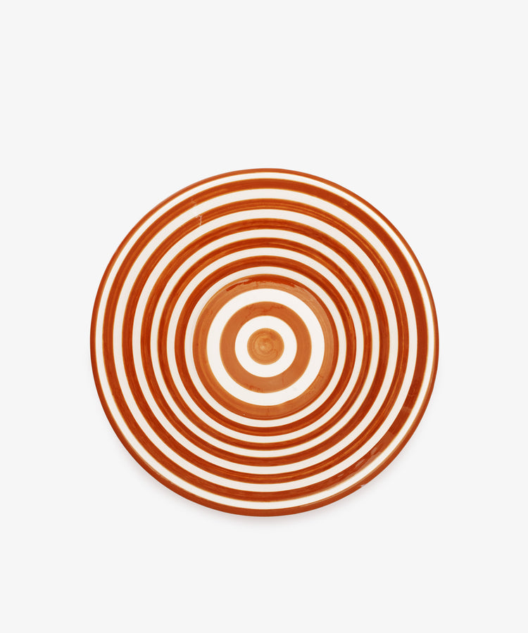 The Natalia Serving Bowl is a round, handmade piece with concentric red and white rings on a white background—ideal as a gift or for pairing with your favorite striped bowl.