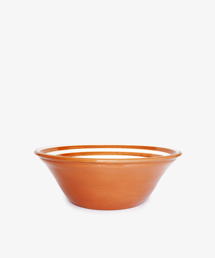 The Natalia Serving Bowl is a handmade, round terracotta clay bowl with a wide rim, shown against a white background.