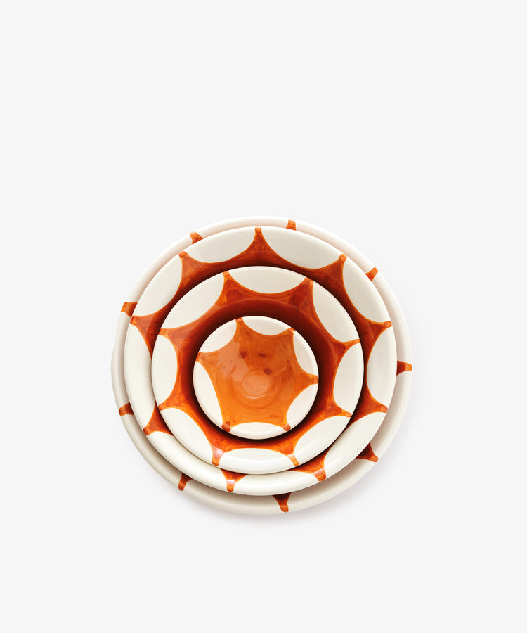 Top view of the Stella Nesting Bowls—three handmade bowls with a geometric orange and white pattern, each with unique variations. Perfect for serving aperitivo snacks, set against a plain white background.