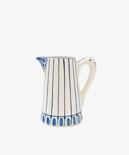 The Jorge Jug is a white ceramic Portuguese jug with blue vertical stripes, oval traditional patterns, a handle, and spout, displayed against a plain white background.