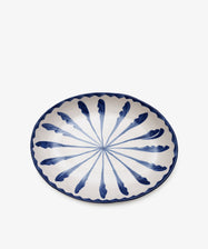 The Rayas Oval Serving Platter is a unique handmade ceramic plate featuring a white base, vibrant blue radial feather pattern, and a blue scalloped edge, displayed against a plain white background.