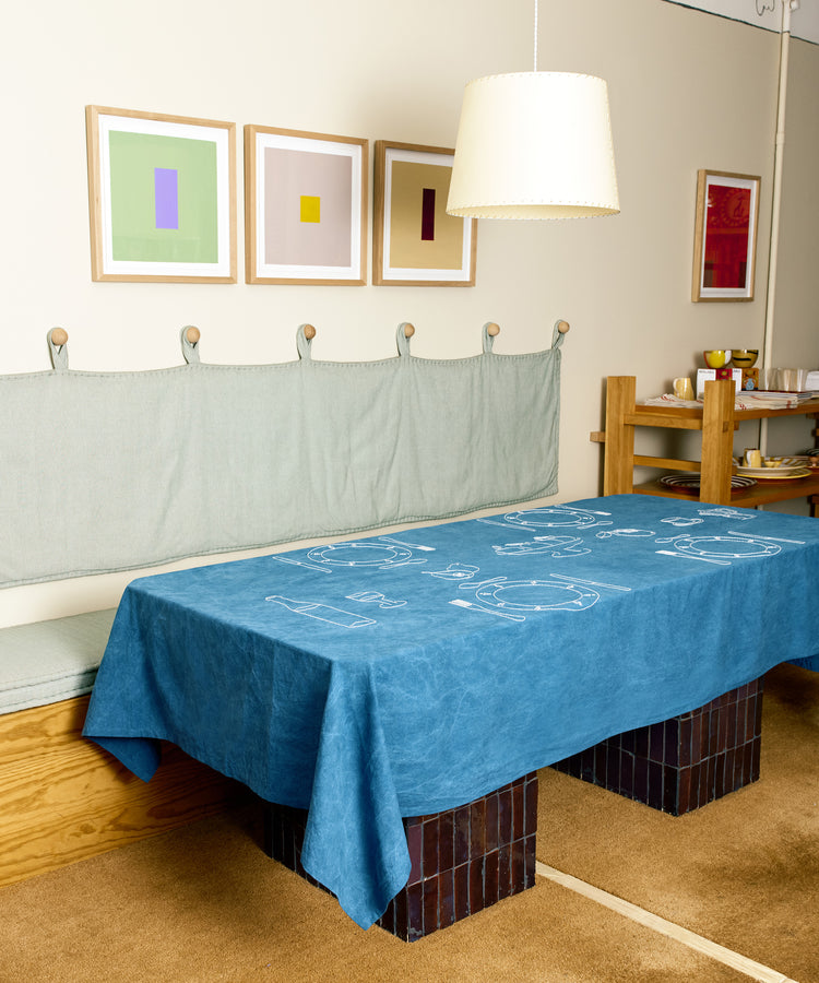 Full room view of Dîner d'Eté tablecloth in indigo linen spread across a table.