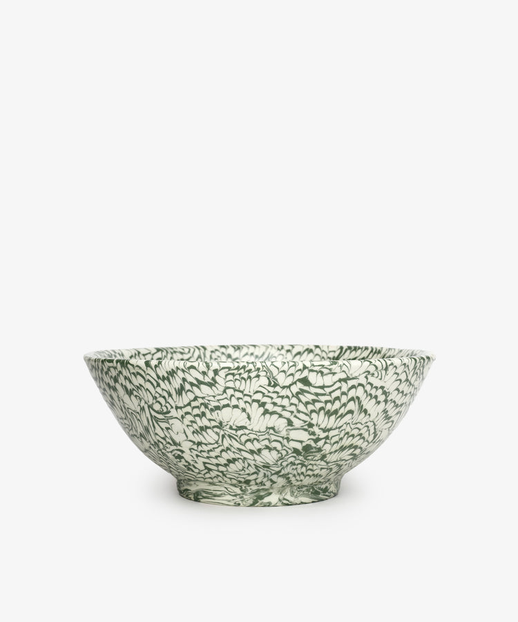 The Celine Salad Bowl is a handcrafted ceramic bowl featuring an intricate green and white floral pattern, set against a plain white background.