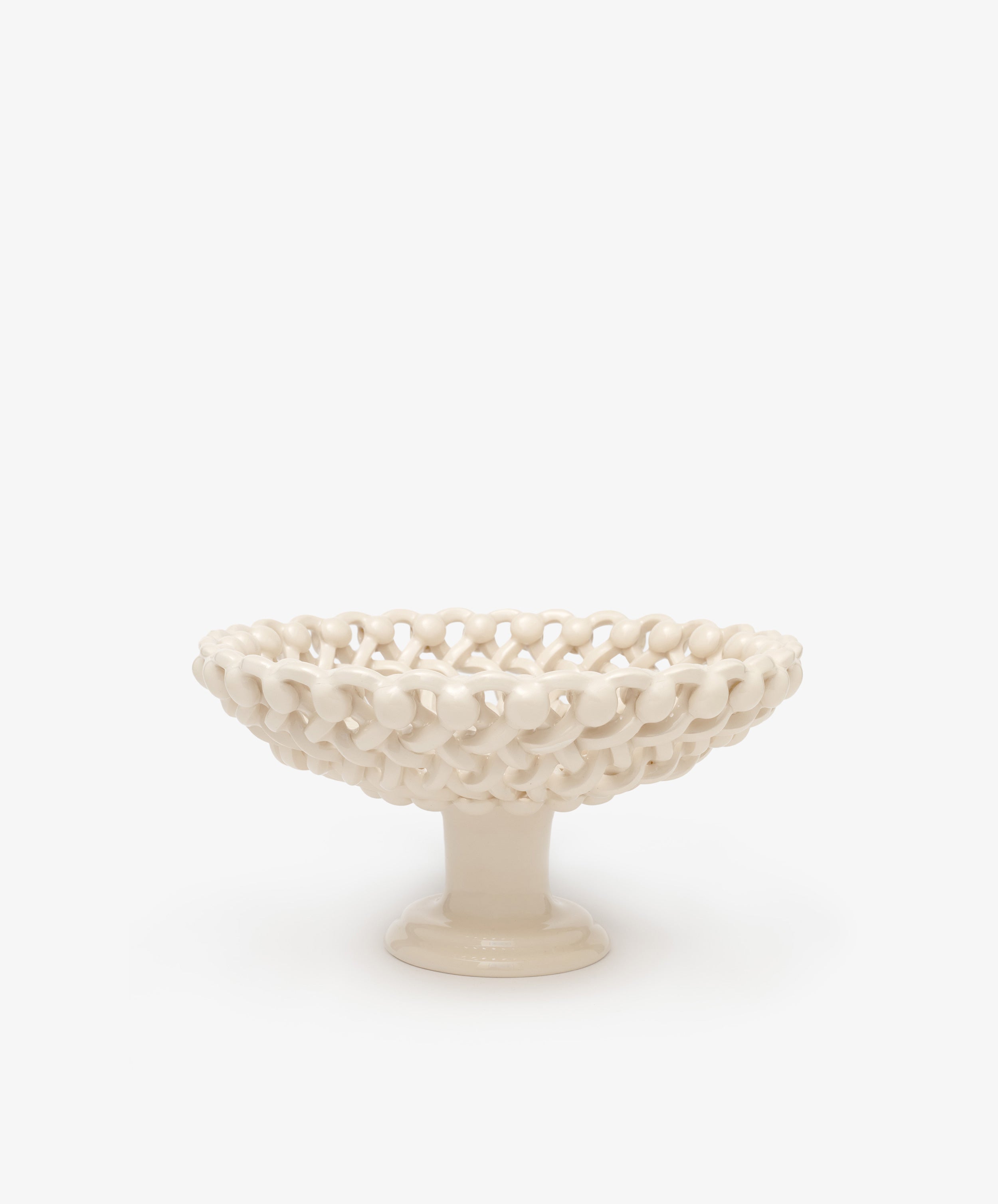 The Remi Footed Bowl features a white ceramic pedestal and open lattice design with hand-braided clay details—an elegant decorative fruit bowl or sculptural accent for any tabletop.