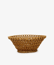 The Remi Decorative Fruit Bowl is a round, shallow wicker basket with an open lattice design, ideal for displaying fruit. Shown here against a plain white background.