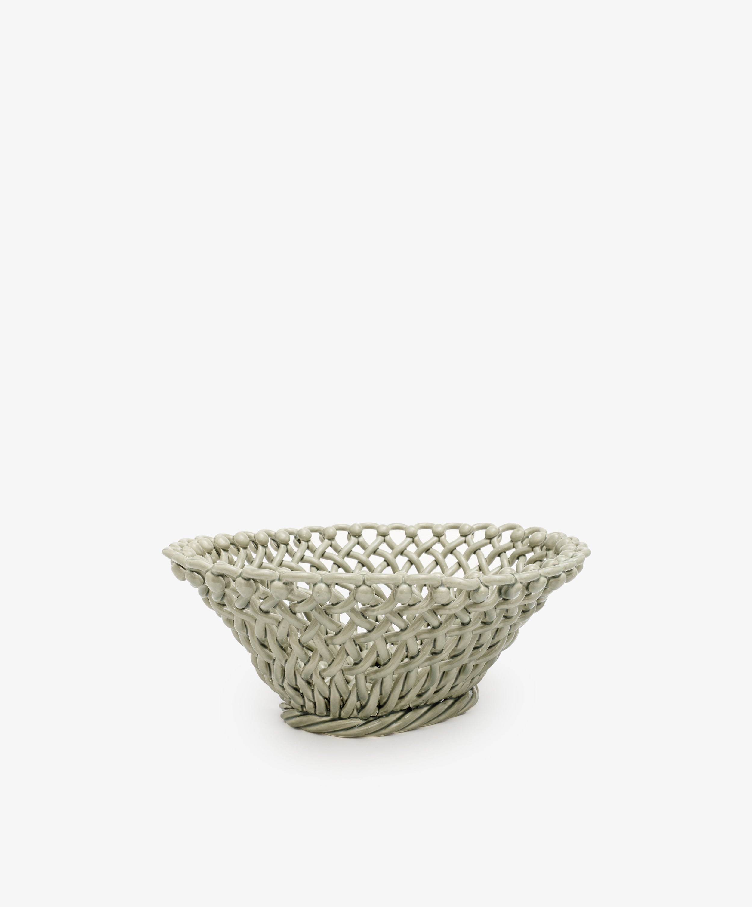 The Remi Decorative Fruit Bowl is a shallow, round woven basket in a light hue, perfect for displaying fruit or adding an artistic touch to any room. Shown on a plain white background.