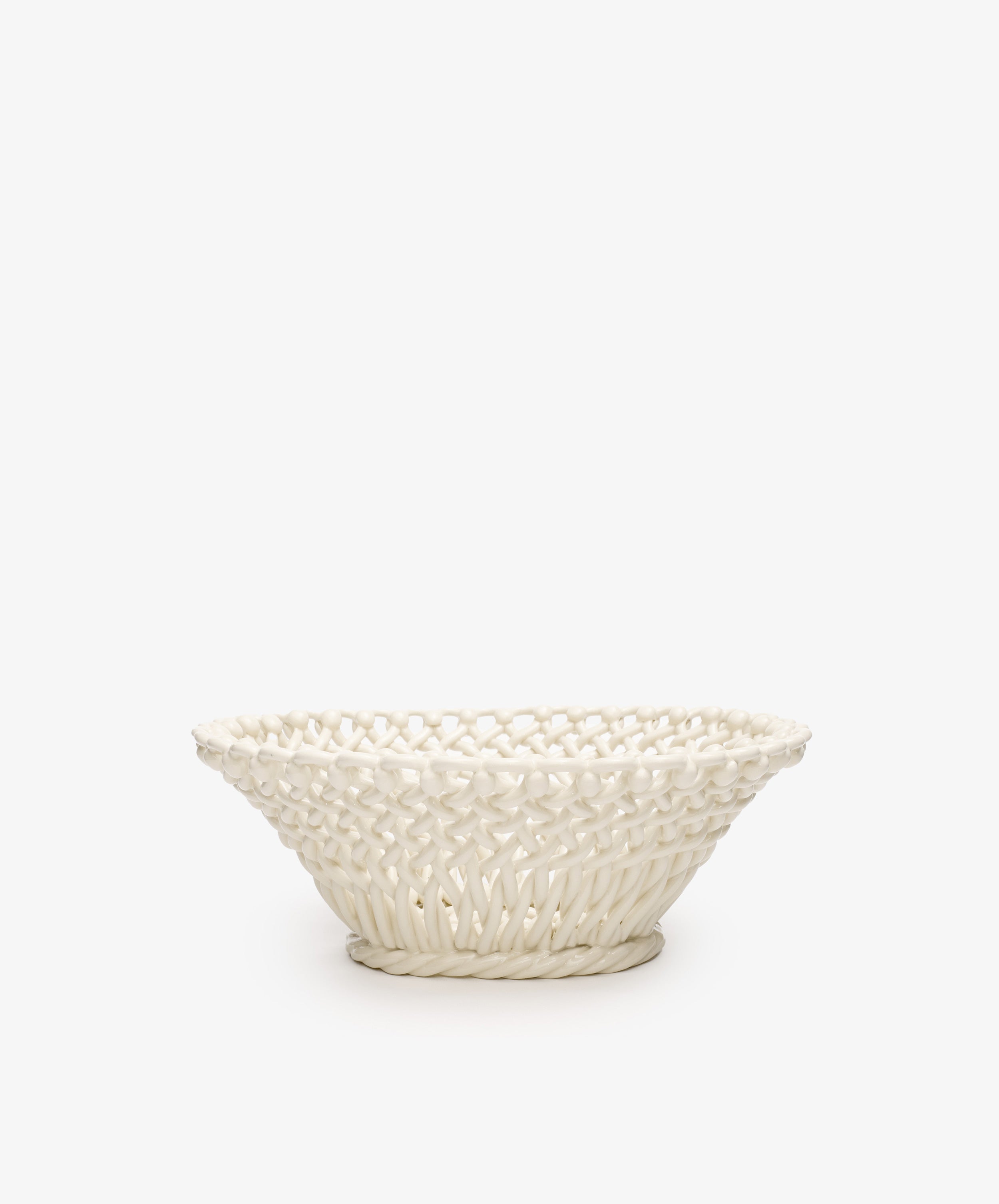 The Remi Decorative Fruit Bowl is a white ceramic woven basket with a wide rim and intricate lattice design, inspired by South of France craftsmanship—perfect as an elegant accent for your home.