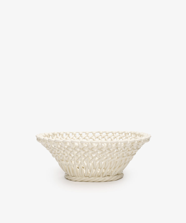 The Remi Decorative Fruit Bowl is a white ceramic woven basket with a wide rim and intricate lattice design, inspired by South of France craftsmanship—perfect as an elegant accent for your home.