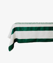 The Riga Tablecloth is an artisanal linen tablecloth with bold green horizontal stripes on a crisp white rectangular surface.