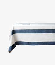 The Riga Tablecloth is an artisanal linen table covering with wide horizontal navy blue stripes on a crisp white background.