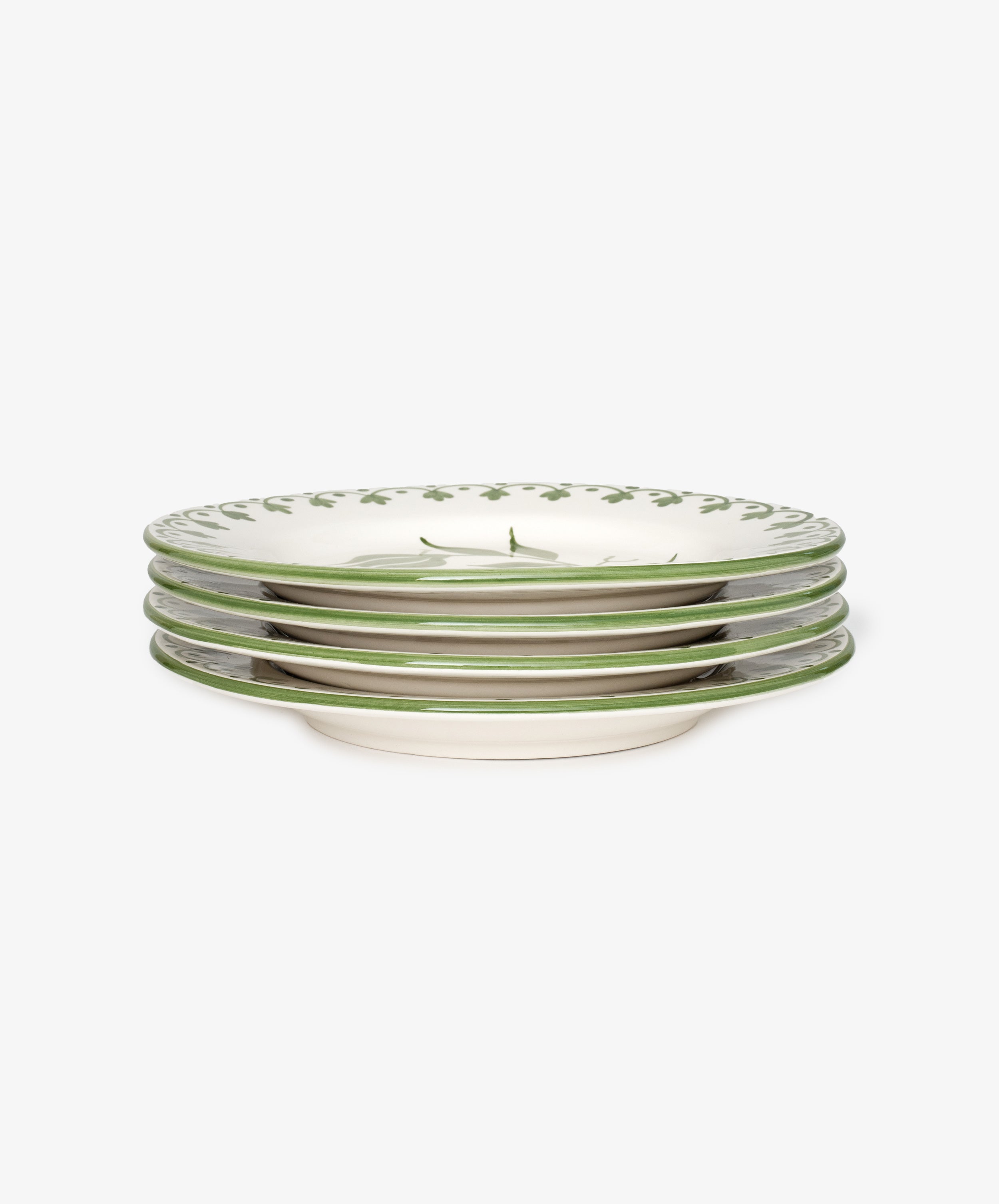 A set of four Esmeralda Dinner Plates, each handmade with a green vine floral design along the rim on a white background.