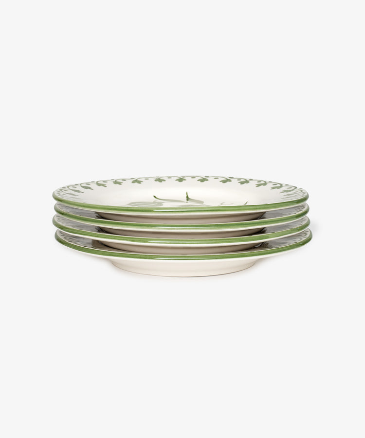 A set of four Esmeralda Dinner Plates, each handmade with a green vine floral design along the rim on a white background.