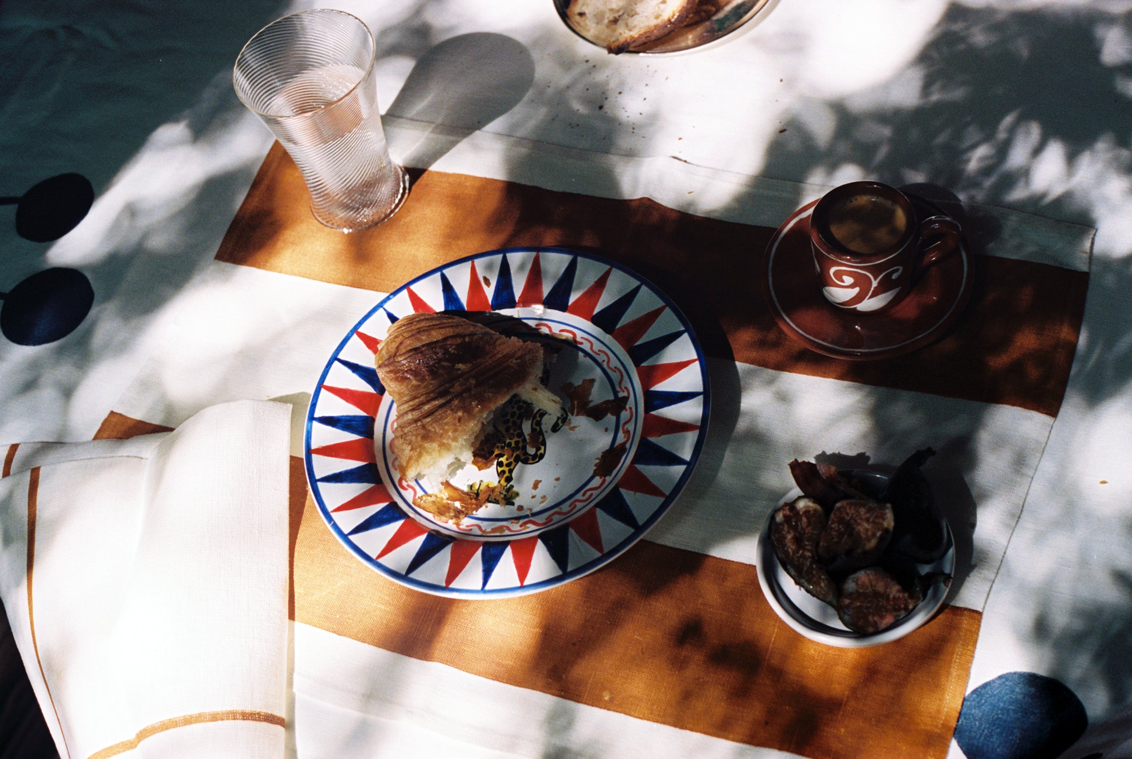 Outdoor tablescape with Riga Placemat and napkin and assorted dinnerware.