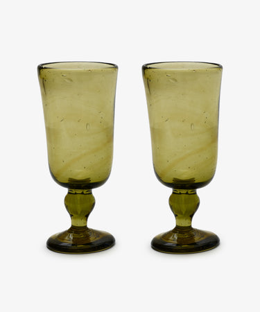 A set of six Elodie Stemmed Wine Glasses, featuring green-tinted bowls, thick stems, and round bases, is arranged side by side on a plain white background.