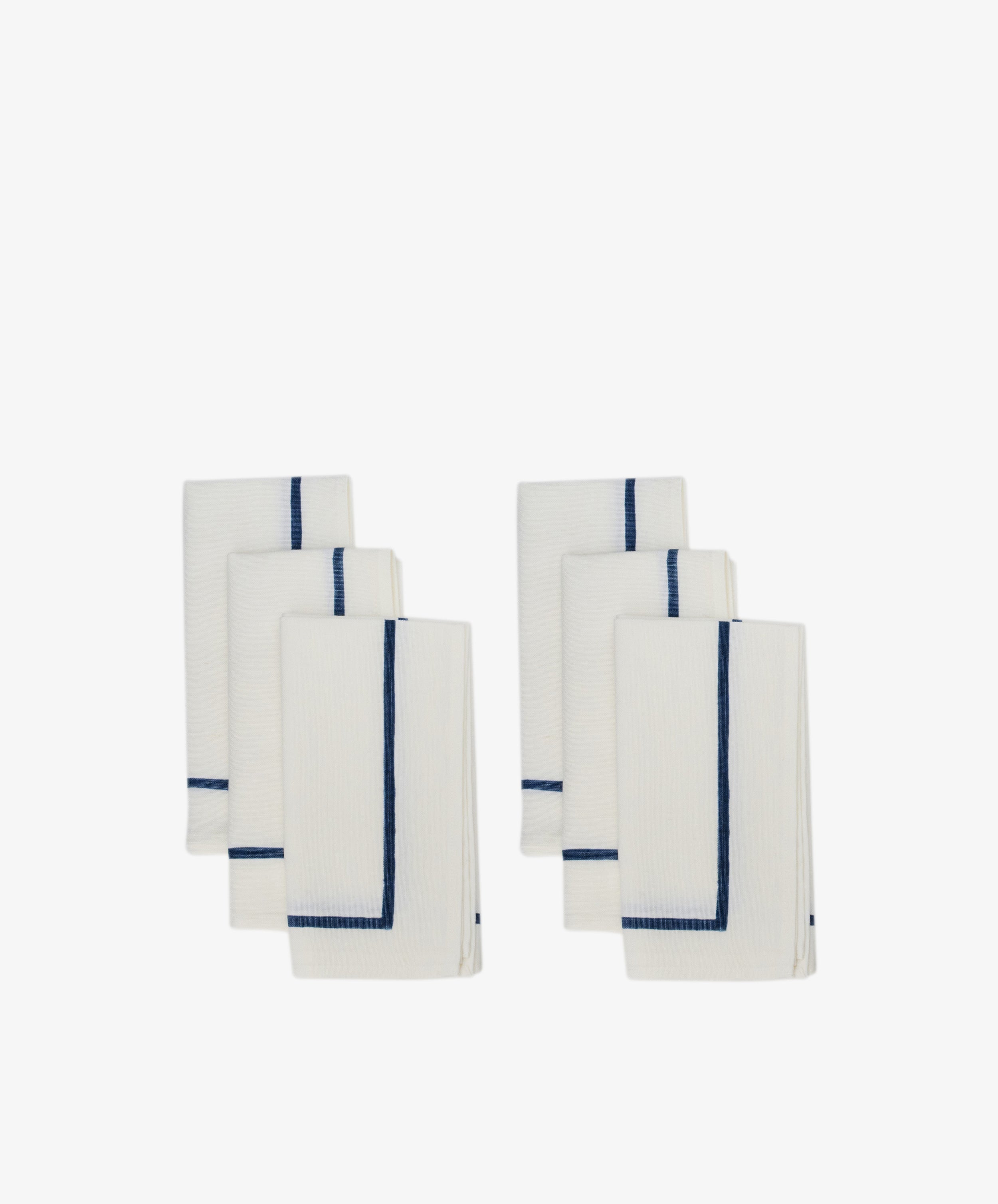 Six neatly folded Riga Napkins, Set of 6, in white with a simple dark blue border, arranged in two groups on a plain white background.