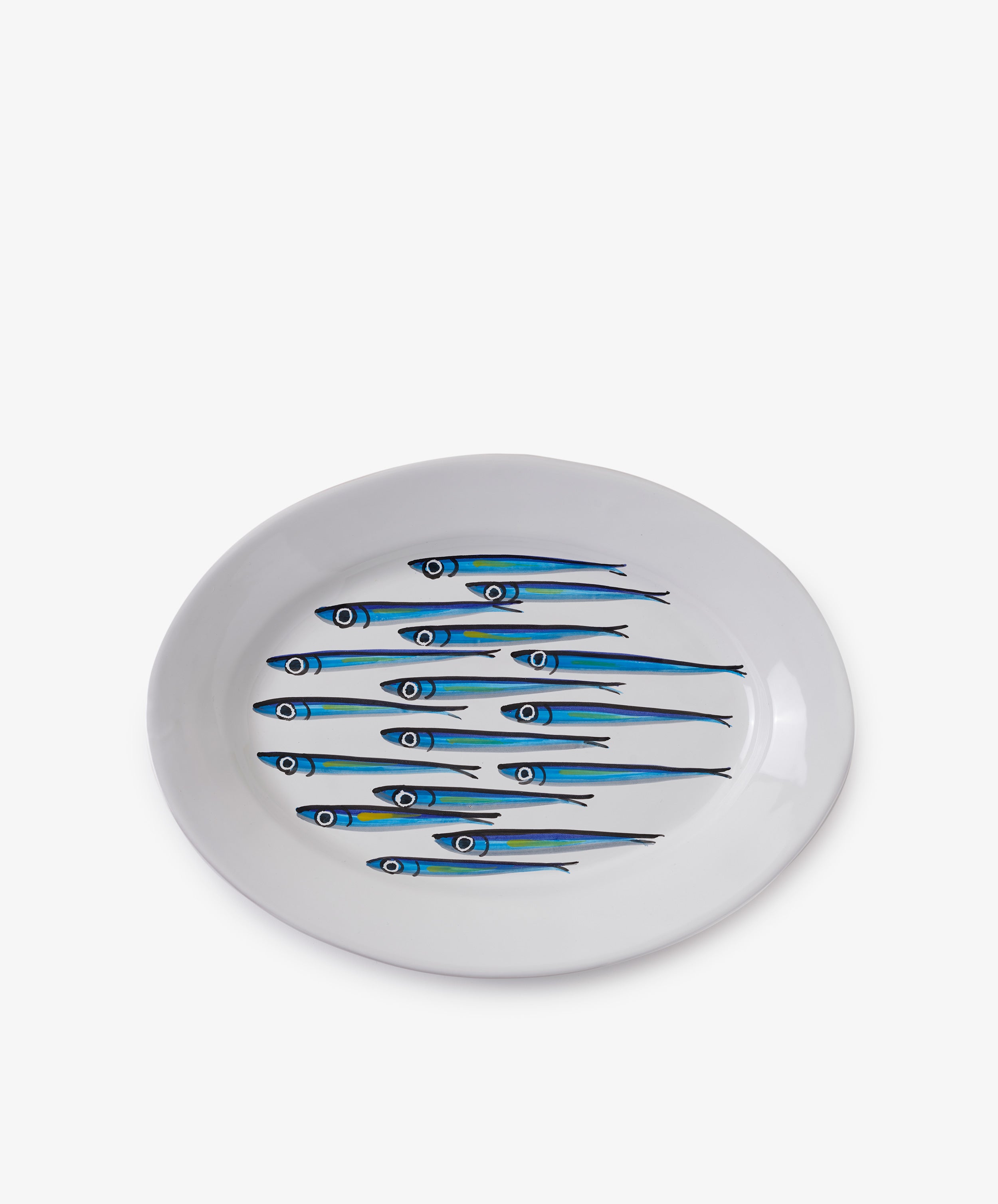 The Tommaso Oval Platter is a white ceramic plate featuring a blue and green sardine design, inspired by the vibrant sea life of the Amalfi Coast.
