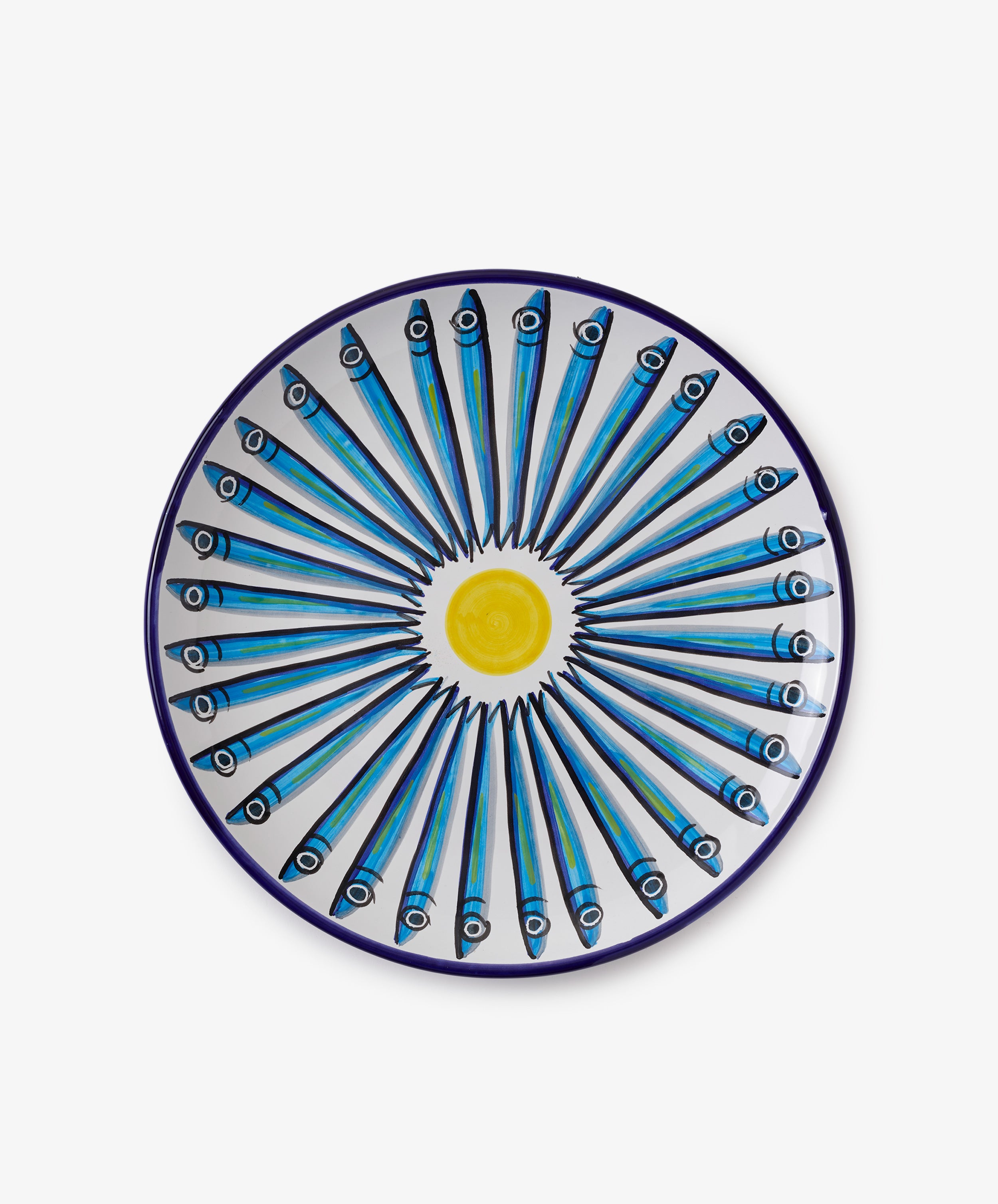 The Tommaso Platter is a round ceramic plate featuring a blue border and a radial pattern of blue sardines facing outward from a yellow center, capturing the vibrant charm of the Amalfi Coast.