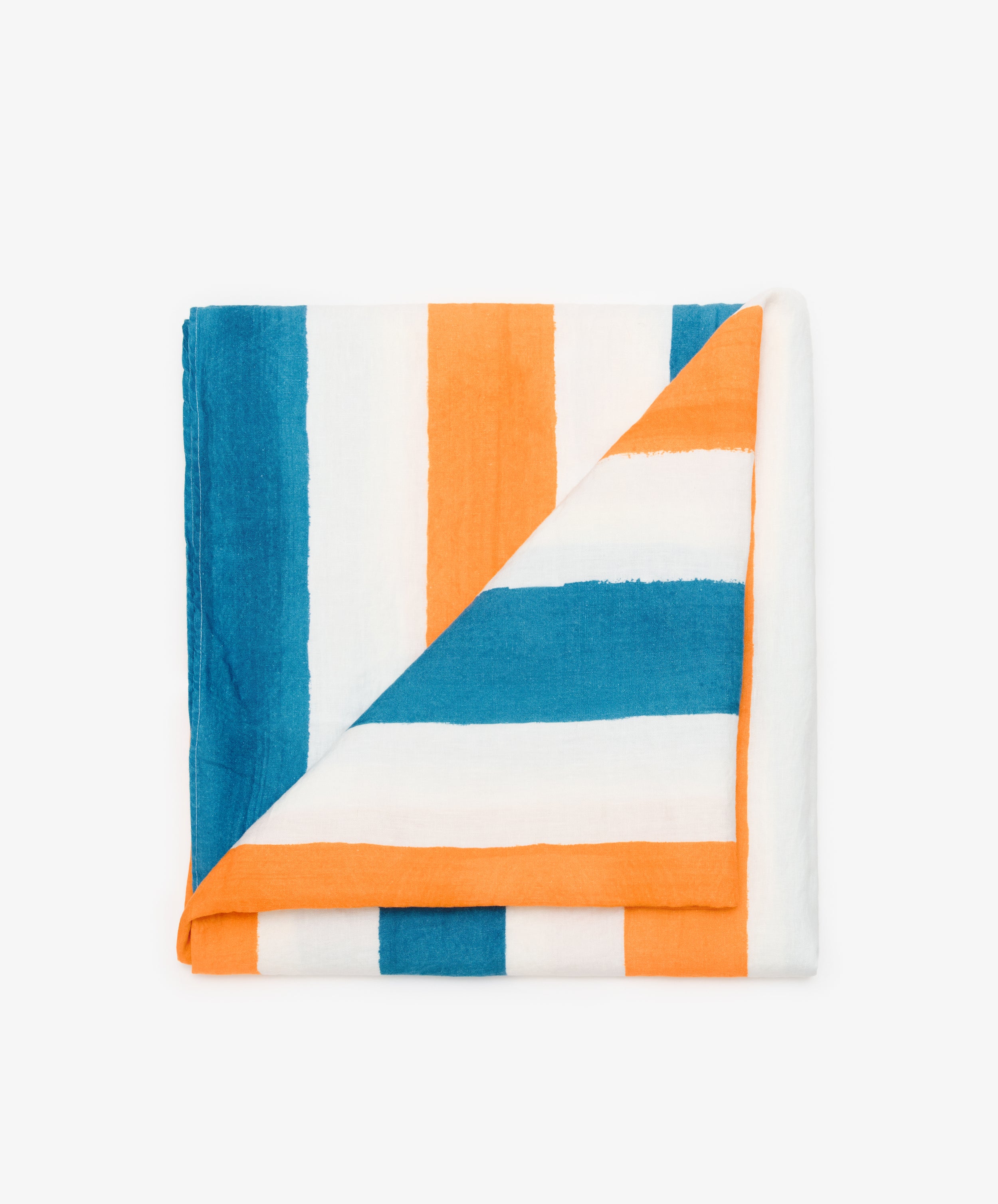 Striped Tablecloth by Summerill & Bishop. Folded white linen cloth in blue and orange stripes, with corner flipped down.