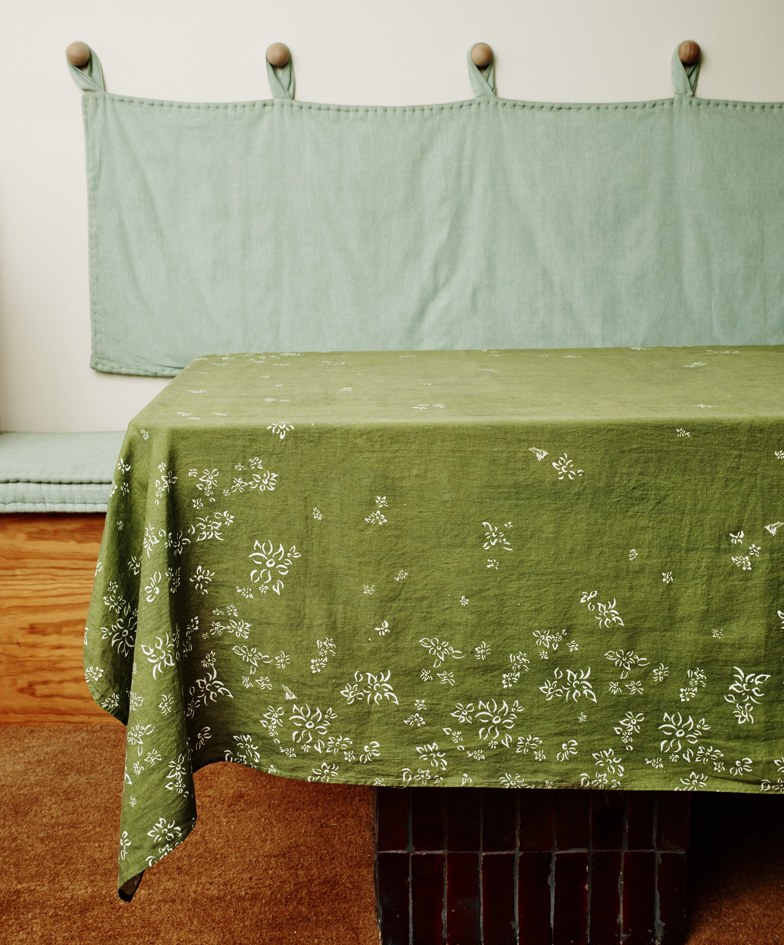 S&Bee Tablecloth. Image of tablecloth draped over a table. Side view.