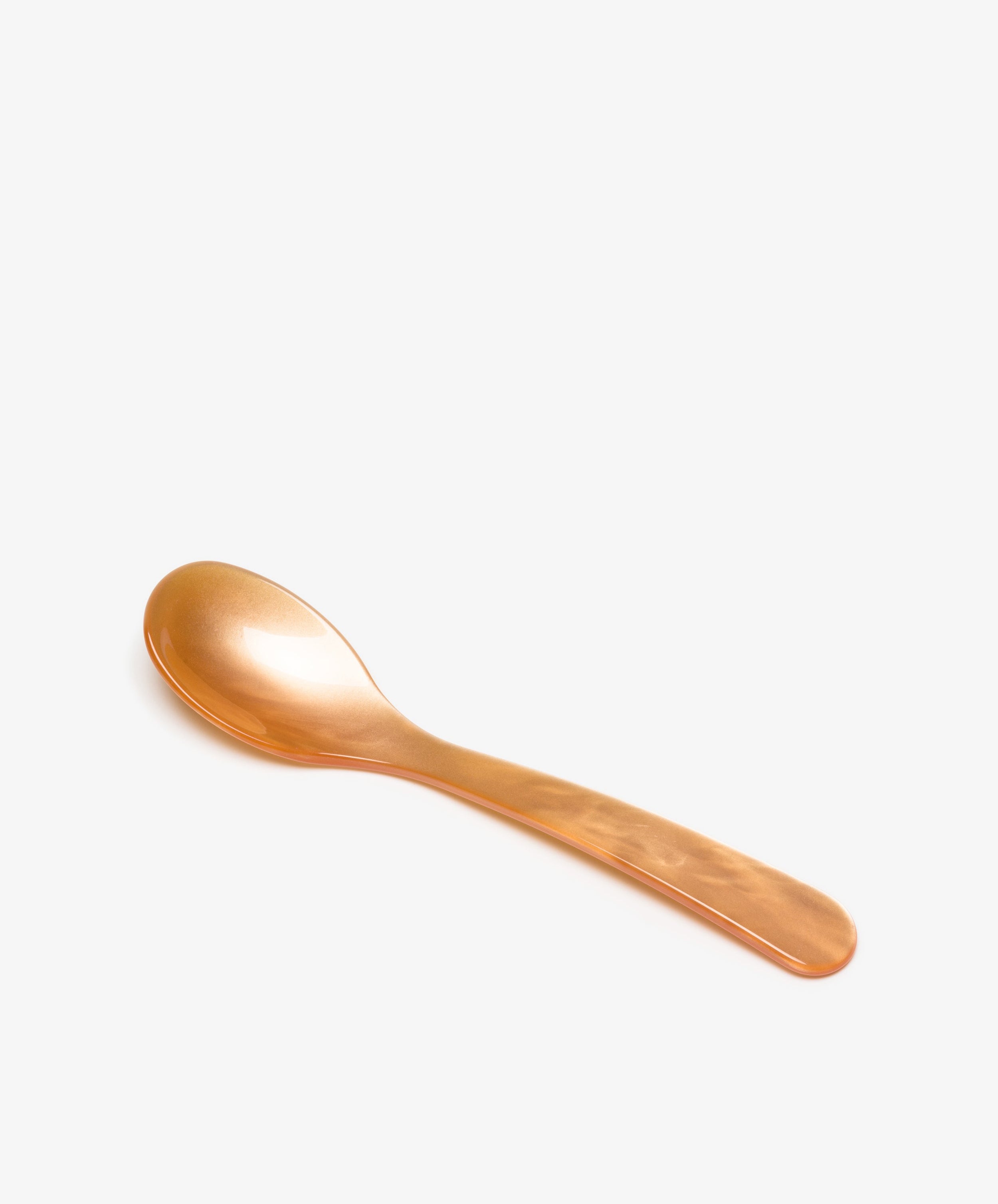 A Piccolo Spoon in orange acrylic is displayed on a plain white background, highlighting its simple design.