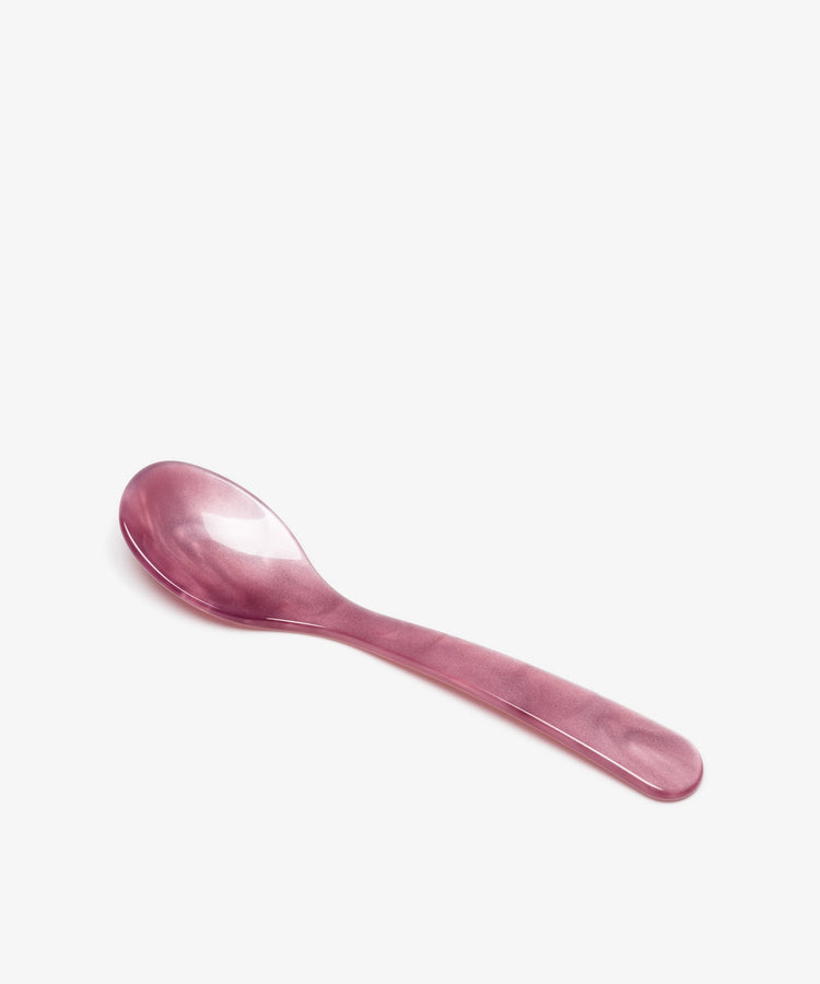 The Piccolo Spoon, made from translucent pink plastic with innovative materials, is displayed on a white background.