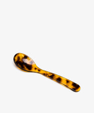 The Piccolo Spoon, featuring a tortoiseshell pattern handle and bowl, is displayed on a plain white background to highlight its elegant design craftsmanship.