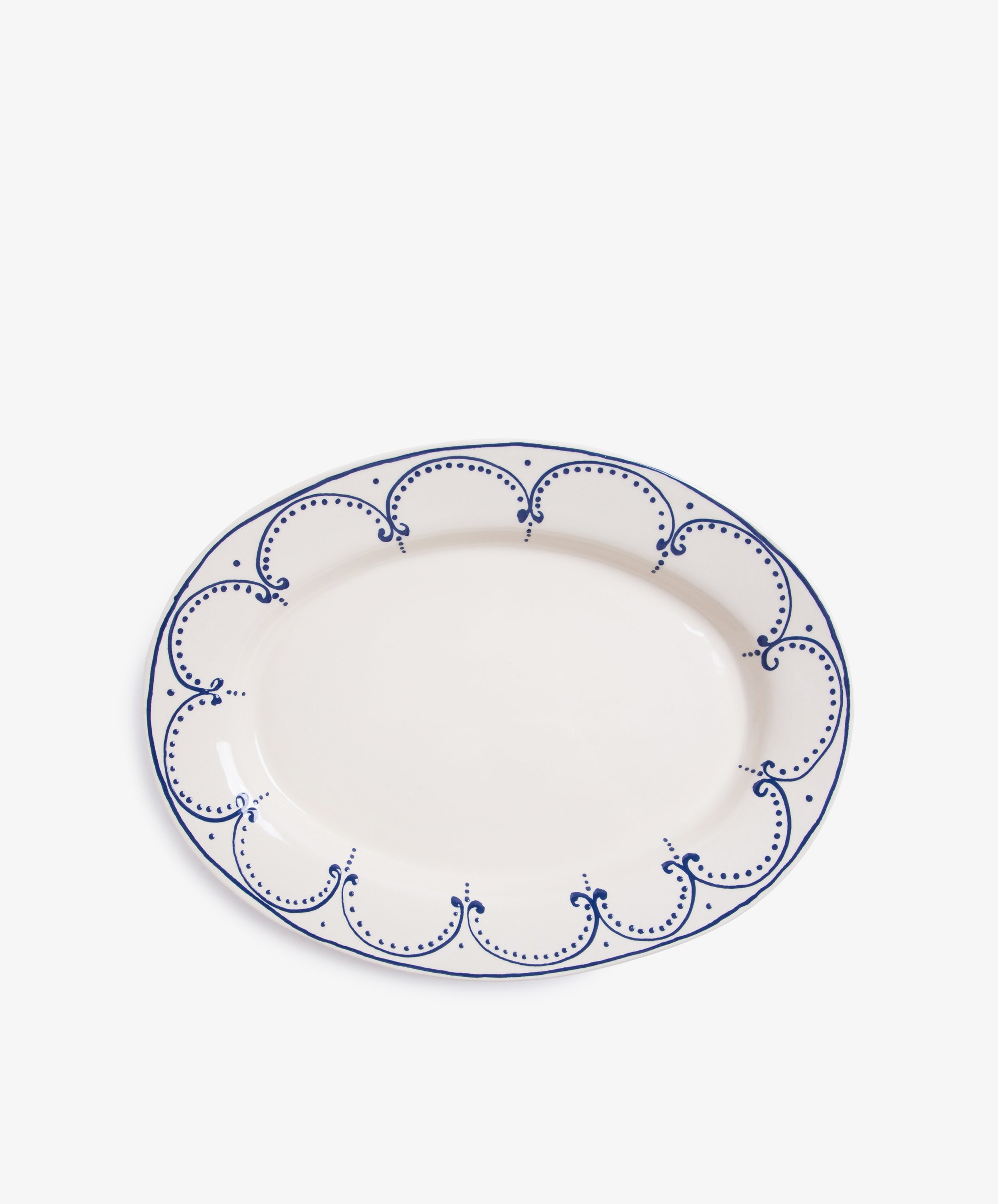 Arco Oval Serving Platter. Overhead view of large white glazed ceramic plate with handpainted blue border design.