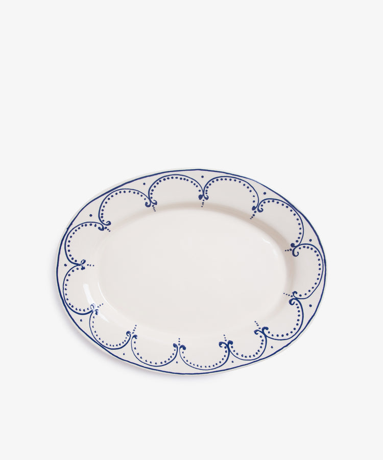 Arco Oval Serving Platter. Overhead view of large white glazed ceramic plate with handpainted blue border design.