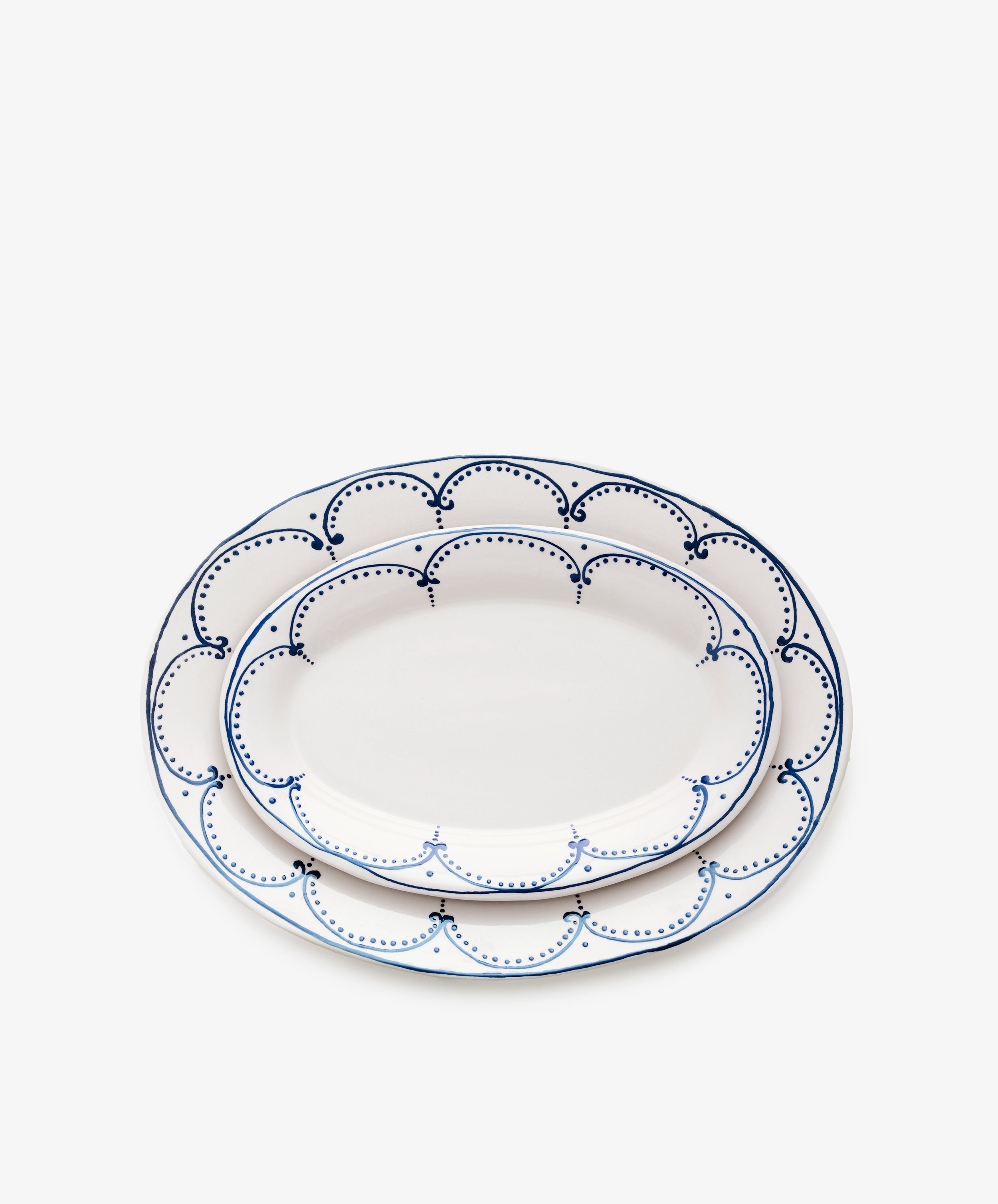 Two sizes of Arco oval serving platters, nested on top of one another.