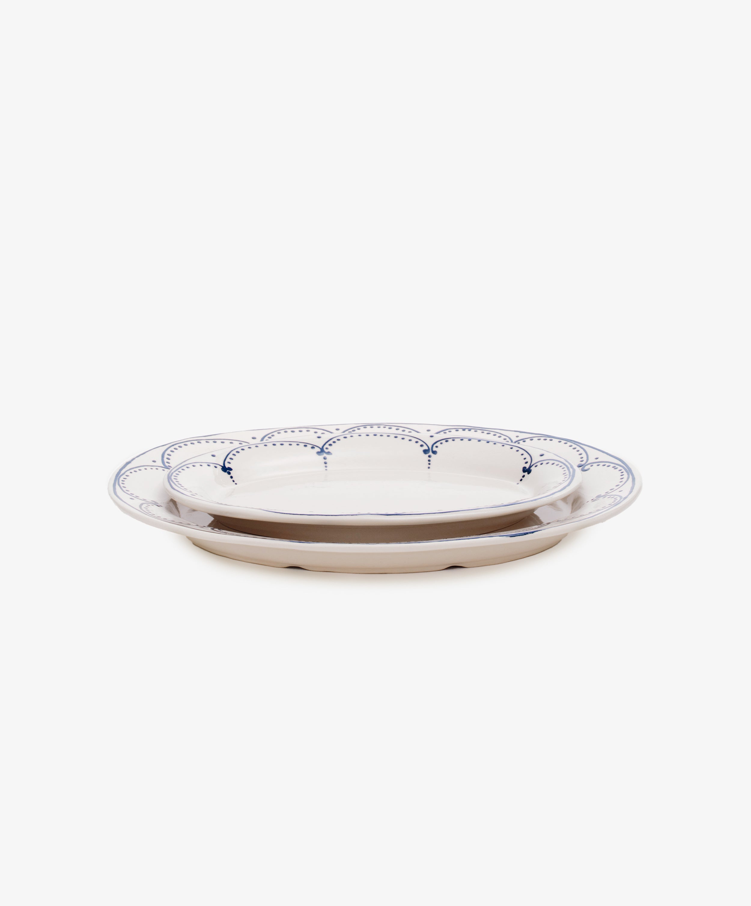 Side view of two sizes of Arco oval serving platters, nested on top of one another.