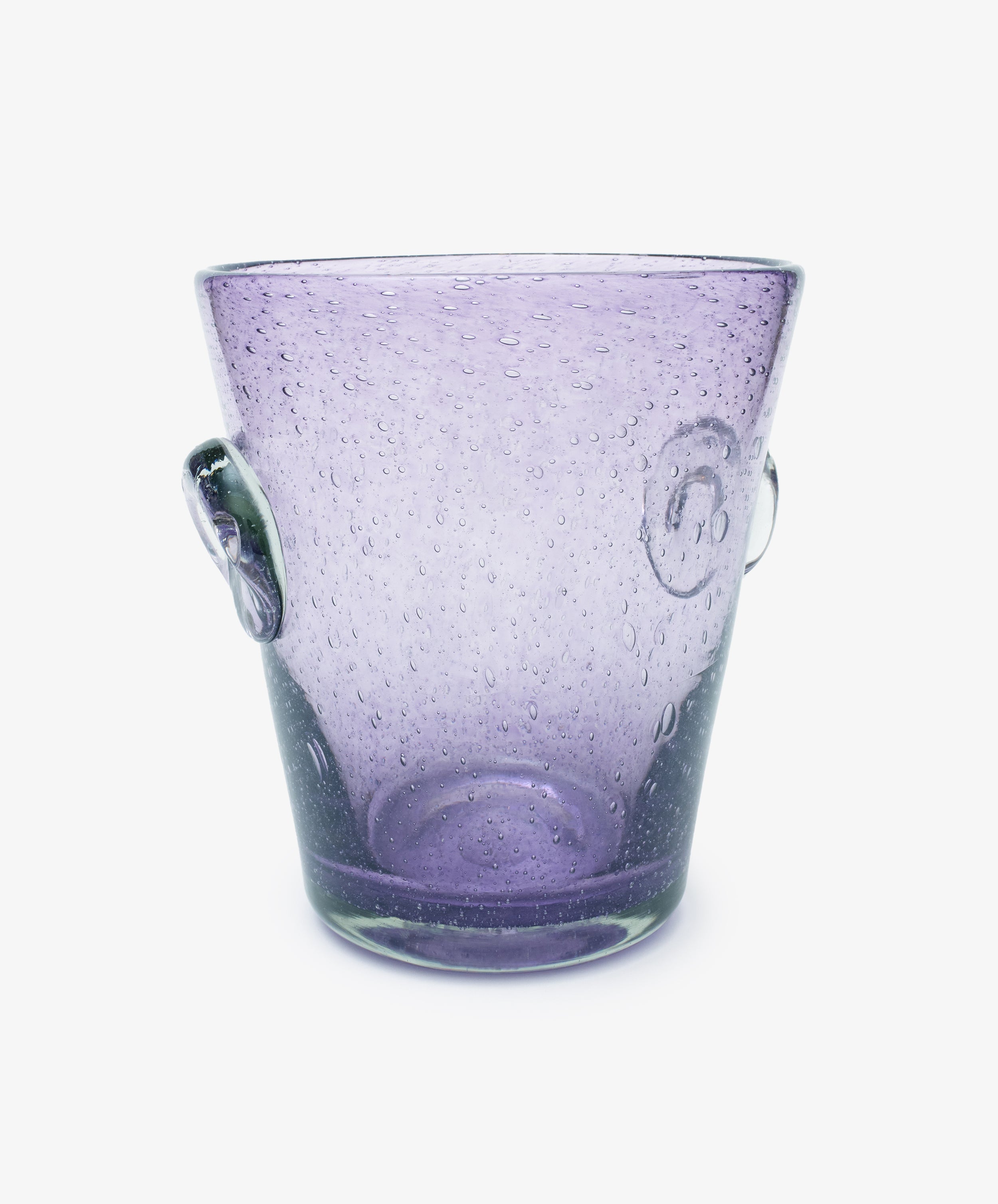 The Lauren Champagne Bucket is a transparent purple glass bucket with two side handles, a translucent surface, and embedded air bubbles, shown on a white background.