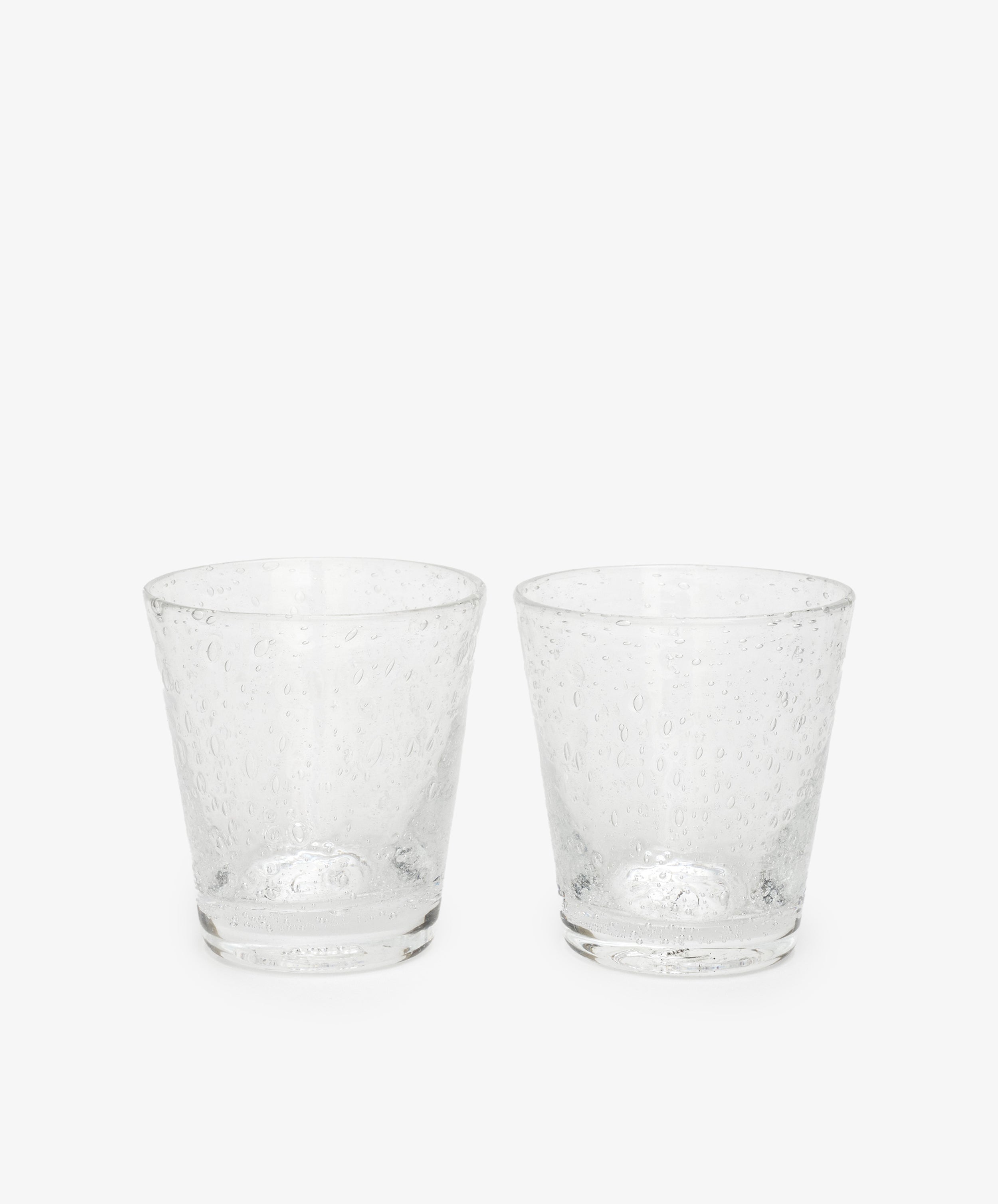 The Lauren Water Glass, Set of 2, features clear, textured glass tumblers with delicate air bubbles across their translucent surfaces, displayed side by side on a plain white background.