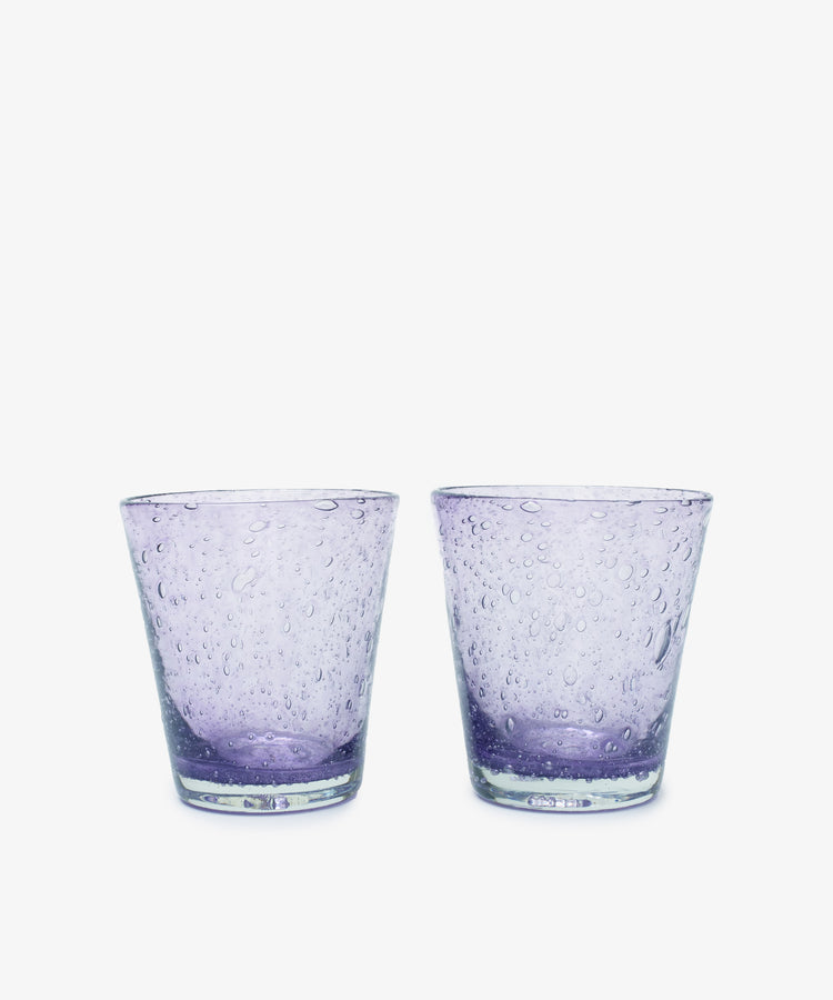 A set of two Lauren Water Glasses, crafted in clear purple glass with a textured bubble pattern and translucent finish, are displayed side by side against a white background.