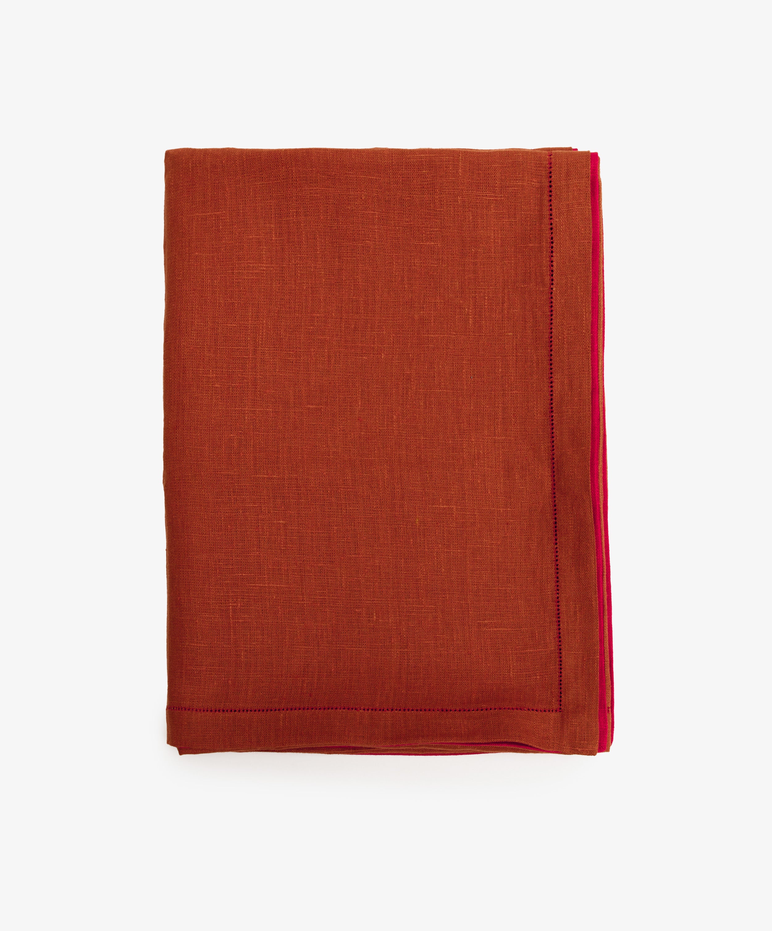 Magnetic Color Field Tablecloth. Folded terracotta linen cloth with red stitching