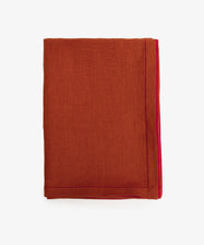 Magnetic Color Field Tablecloth. Folded terracotta linen cloth with red stitching