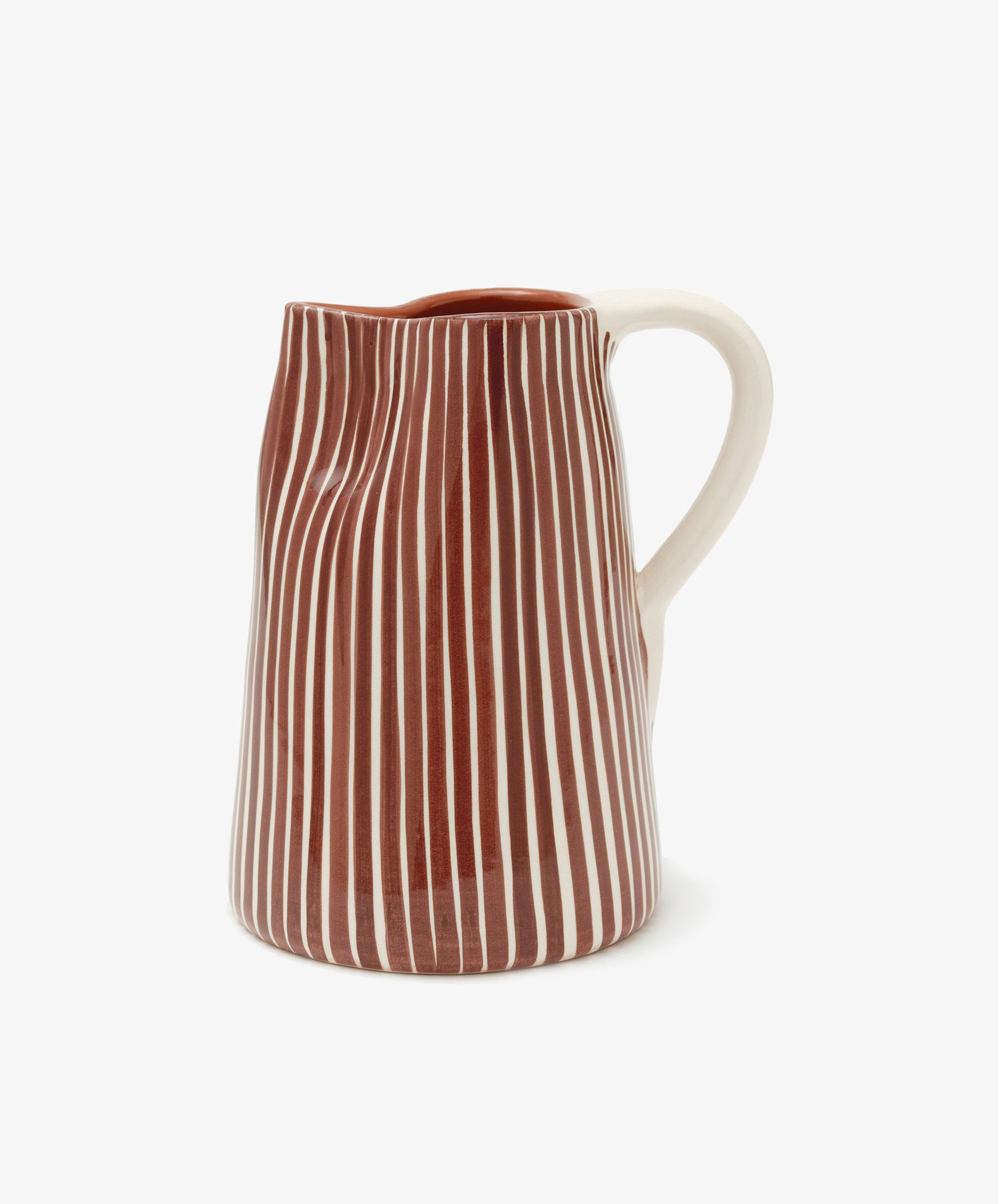 The Natalia Water Jug is a ceramic jug with a white handle and body, featuring vertical brown and white stripes. It is photographed against a plain white background.
