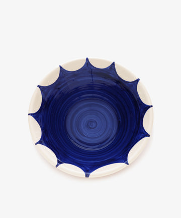 Stella Serving Bowl. Overhead view of glazed terracotta bowl in white with dark blue design.