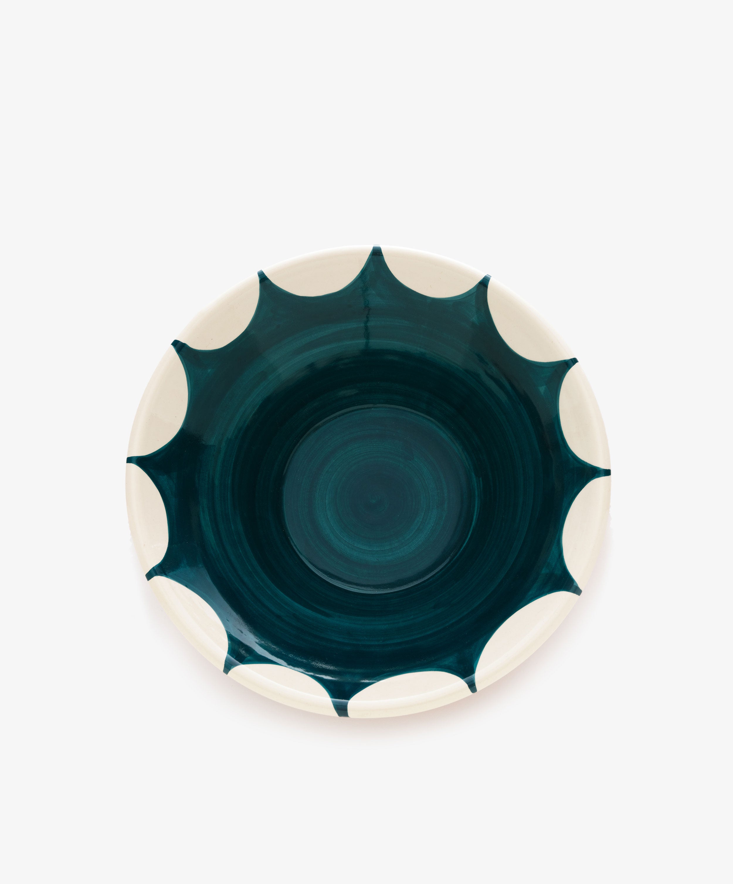 Stella Serving Bowl. Overhead view of glazed terracotta bowl with white rim and dark green design