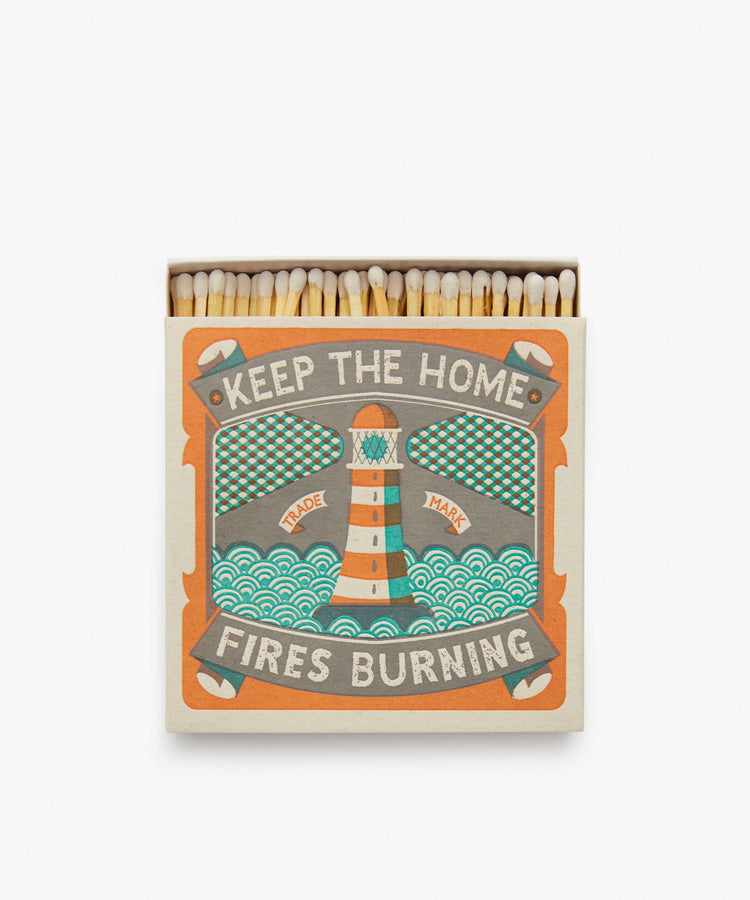 Keep the Home Fires Burning, Luxury Matches. Teal and orange box with lighthouse illustration and matches peeking out.