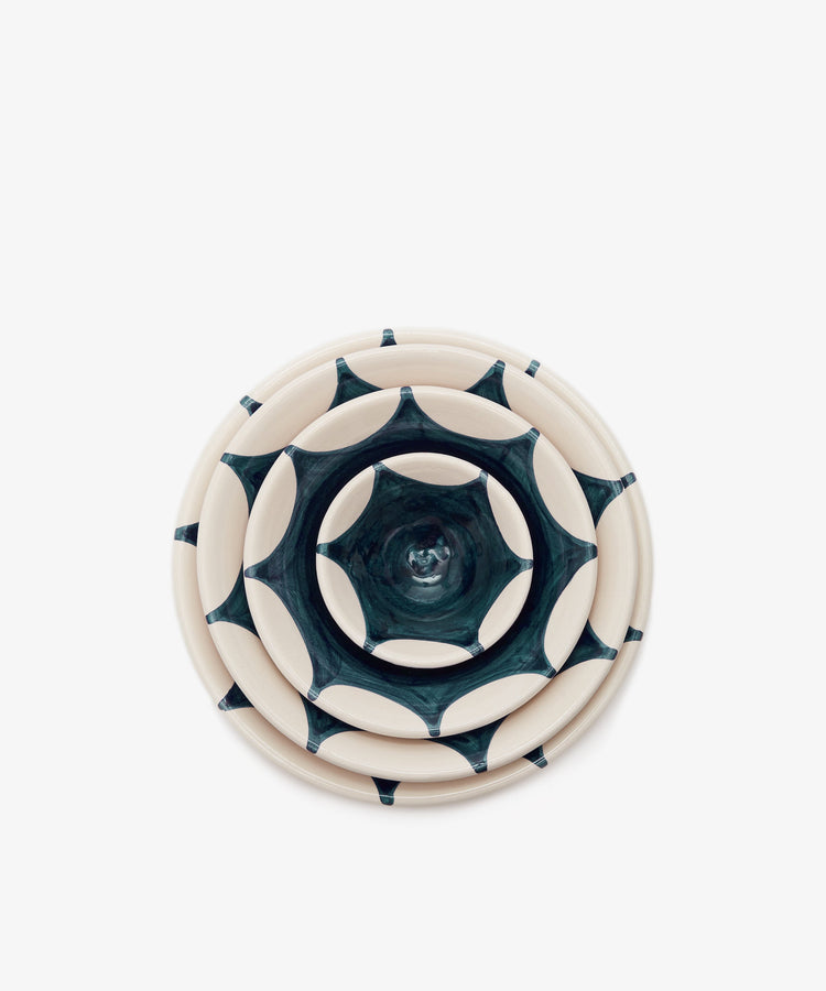Stella Nesting Bowls. Overhead view of 4 nested glazed terracotta bowls in white with dark green design.