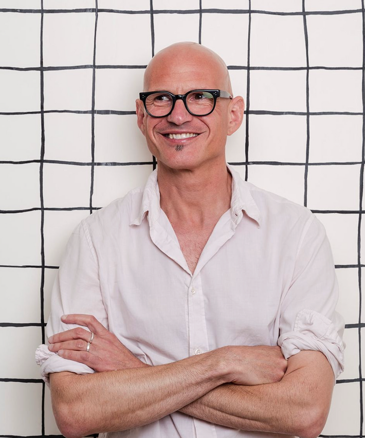 bald man with glasses with folded hands