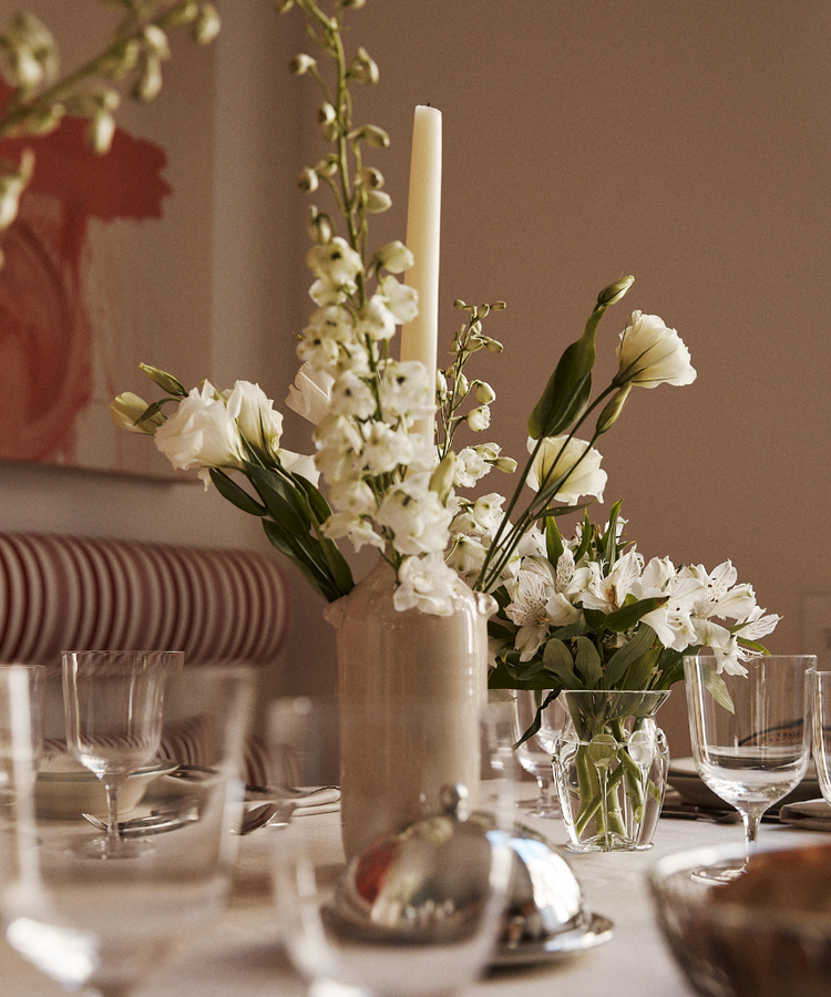 Vase with flowers and a candle on a tablescape