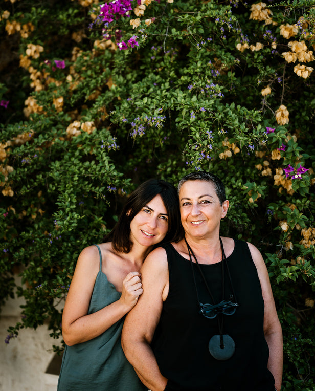 mother and daughter outside in in front of garden wall