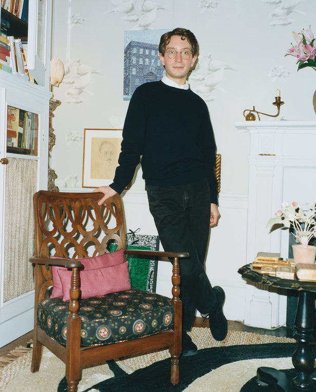 man posing next to chair
