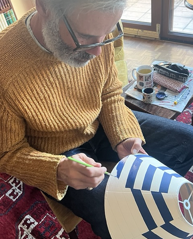 Man painting a striped lampshade by hand