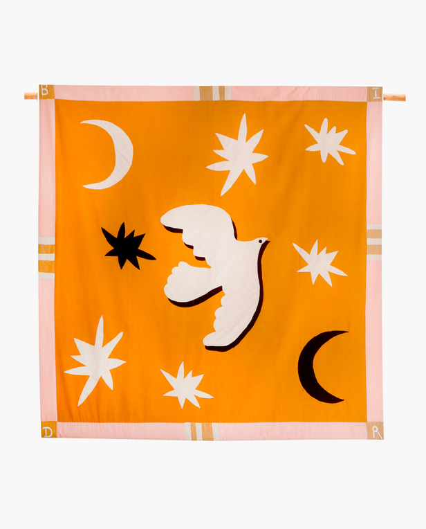 orange quilt with white dove on it