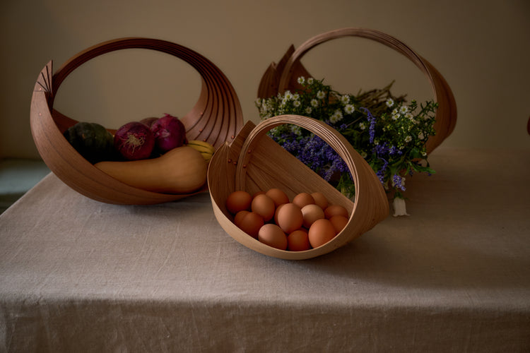 wood baskets with eggs flowers and vegetables in them